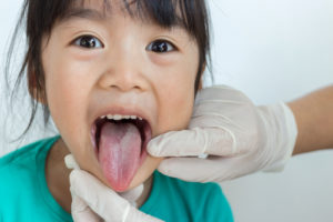 Girl showing tongue to dentist