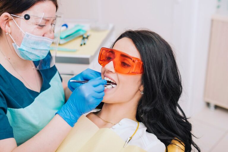 Young lady having her mouth inspected by dentist