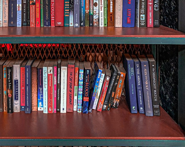 Books on shelf with missing books causing books on either side to collapse inwards